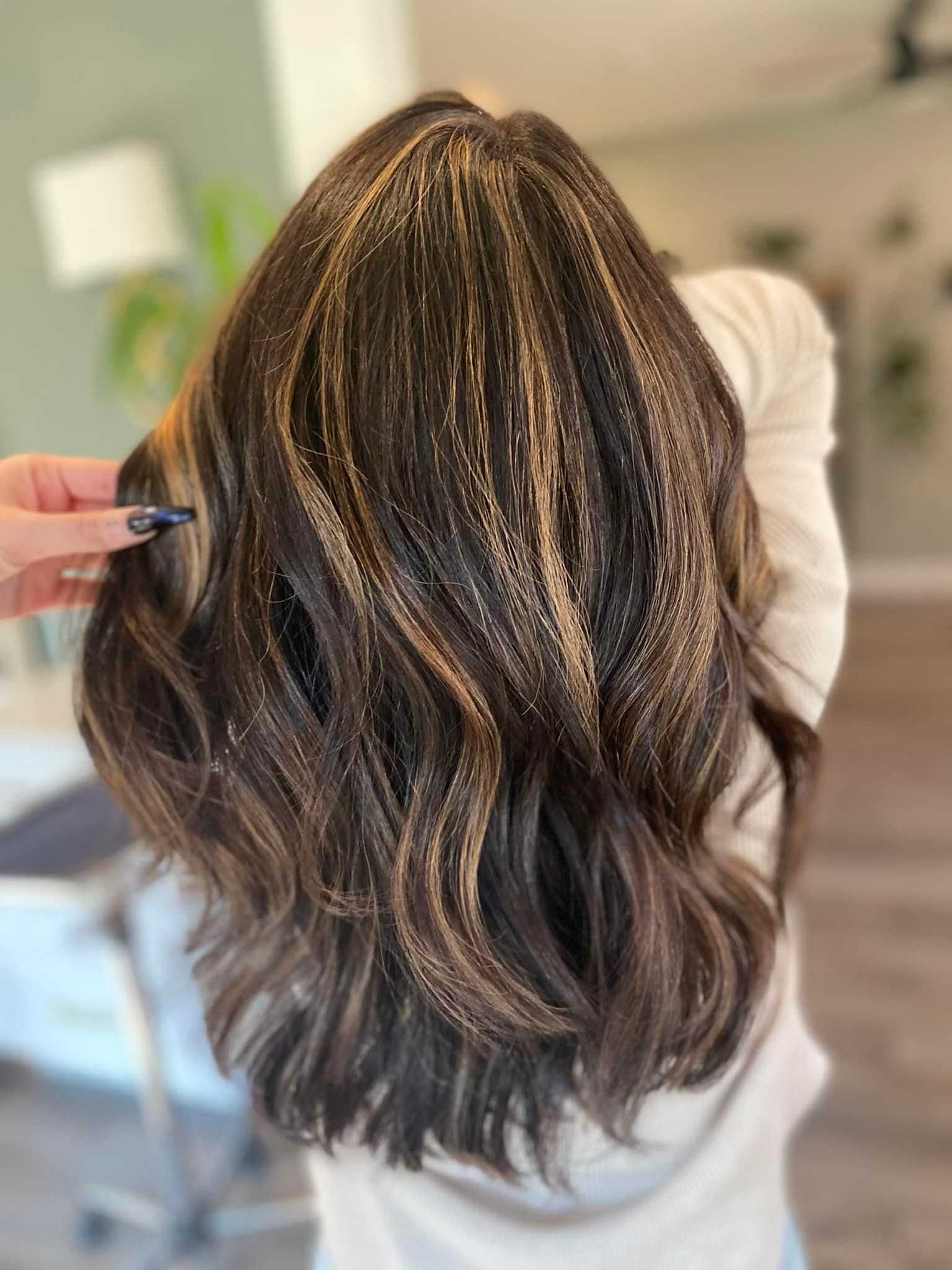 Wavy hair with highlights styled in a salon setting.